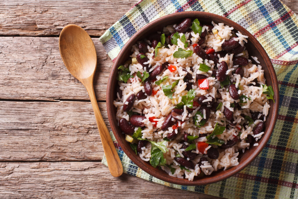 Gallo Pinto dish on a wooden table with a wooden spoon