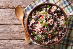 Gallo Pinto dish on a wooden table with a wooden spoon