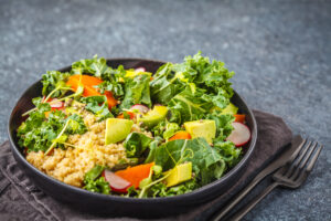 Kale, Quinoa and Avocado Salad in a dish on a grey table