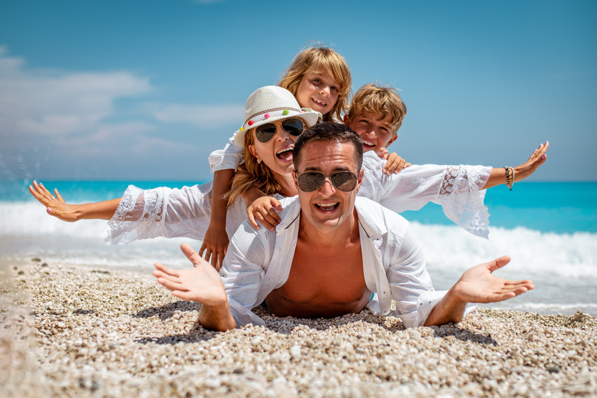 family of four having fun on a sandy beach