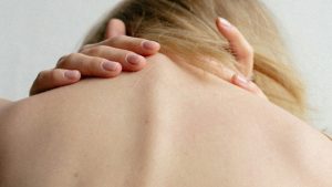 prevent surgery with injection therapy - woman rubbing her aching neck