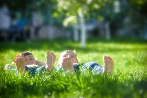 two happy boys laying in the grass