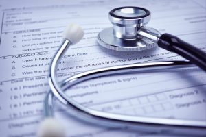 stethoscope on top of insurance papers