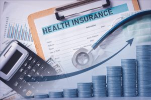 Health Insurance papers, a calculator, a chart of coins going up