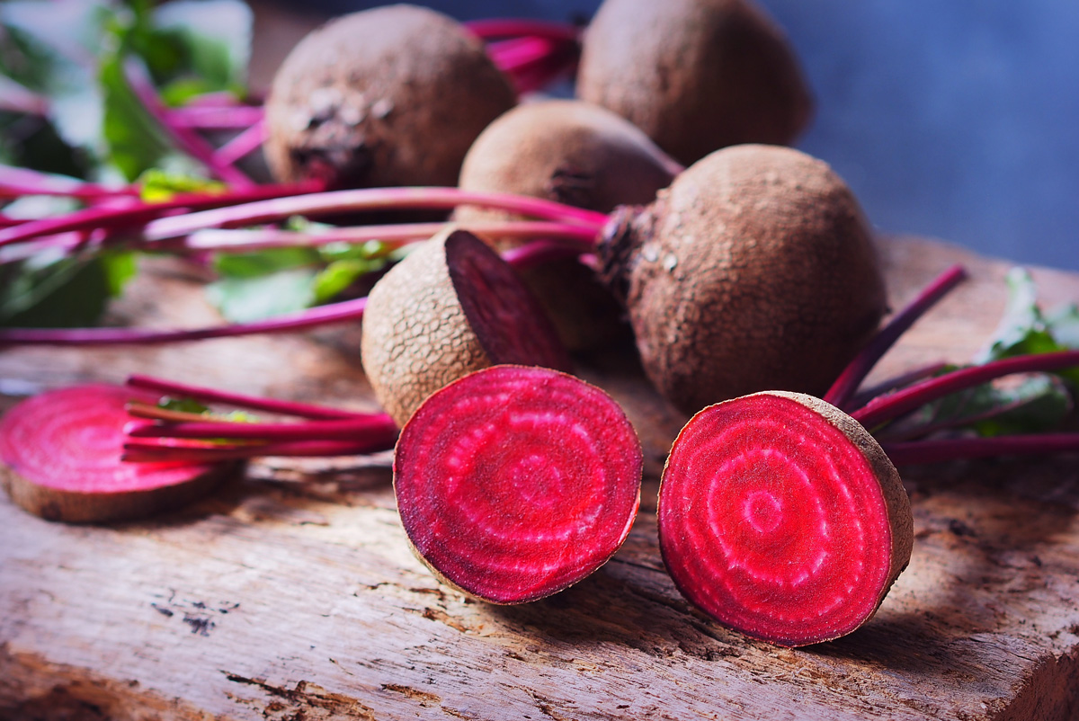 Red beets on a cutting board, one cut open