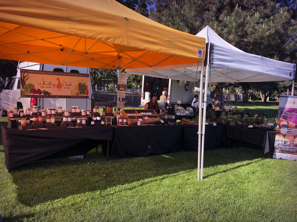 Whistling Duck farm stand with yellow tents on grass