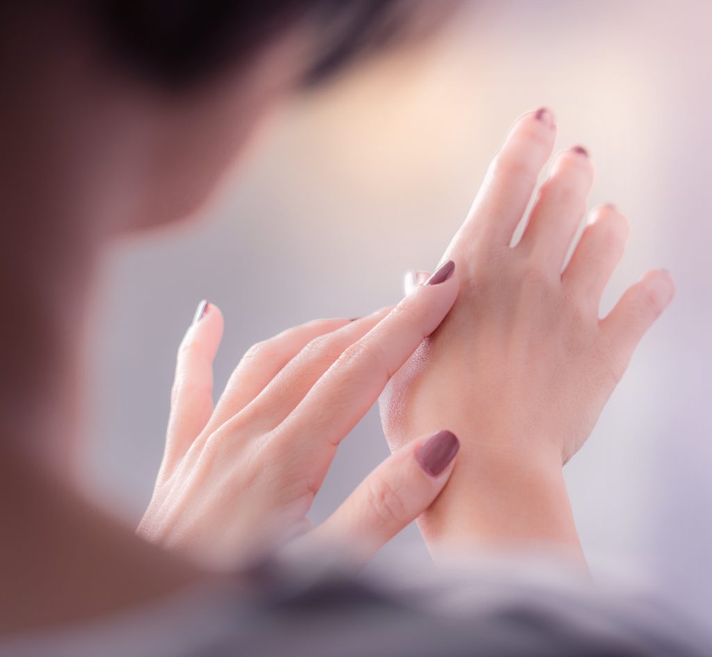 Woman putting lotion on her hands