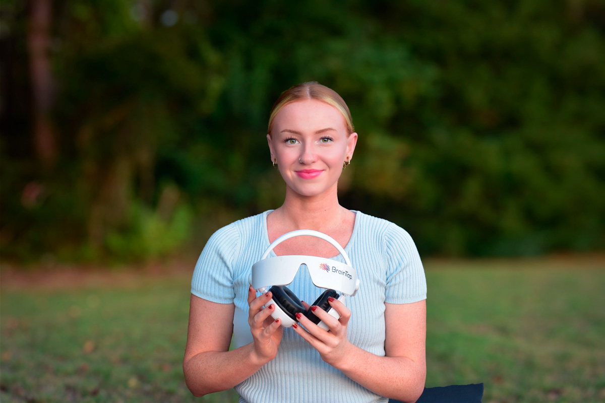 Woman in nature holding the BrainTap headset